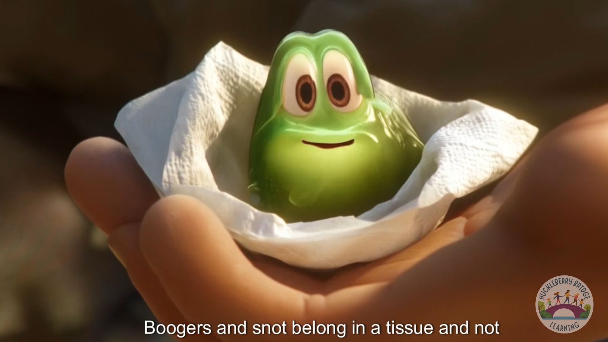 Silly-looking cartoon booger in a tissue. The tissue is in a child's hand.